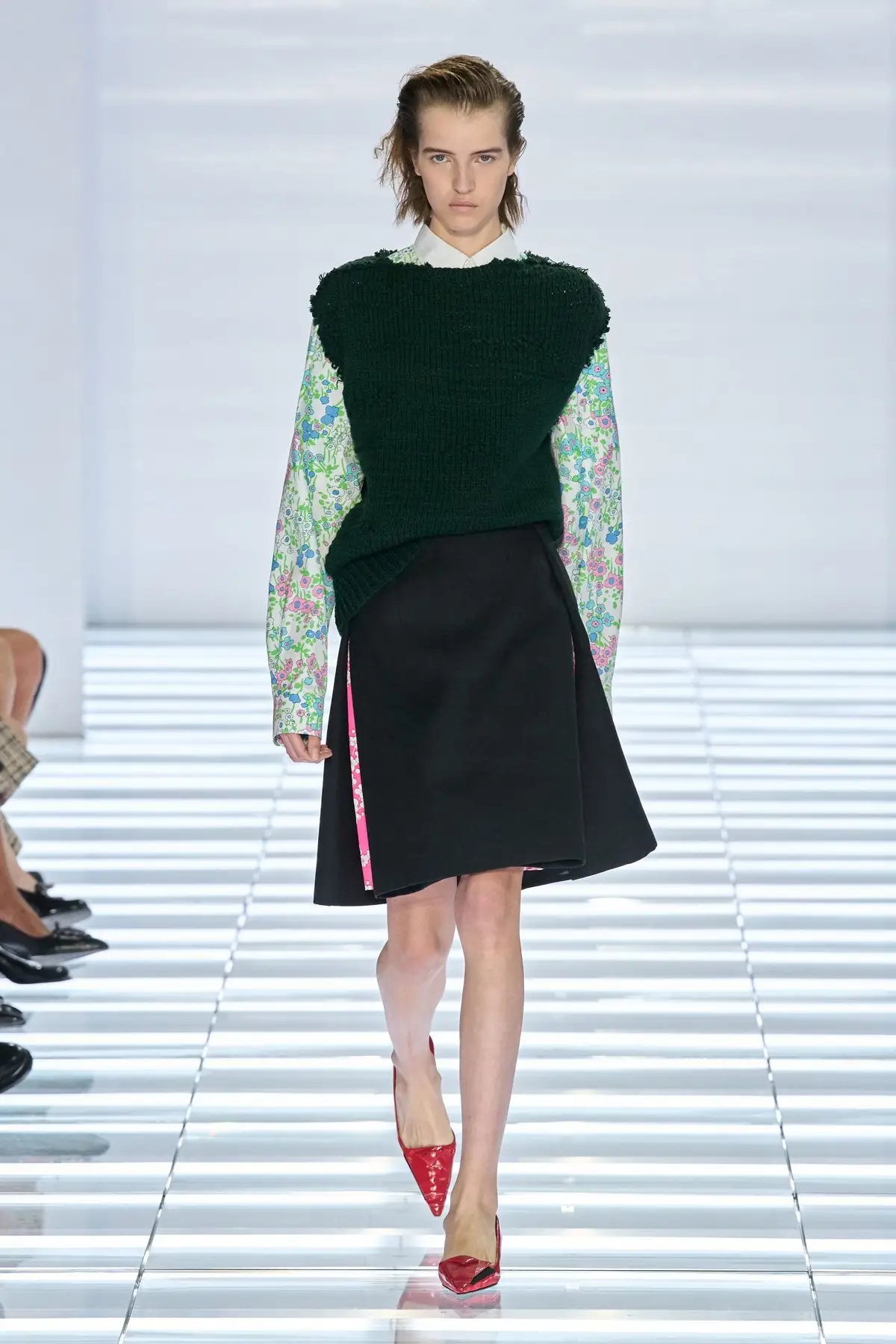Look 49. Black wrap skirt, dark knit over printed sleeves.