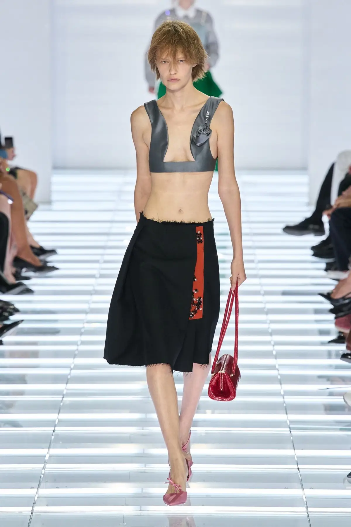 Look 58. Black wrap skirt with a red tie, grey bra top.